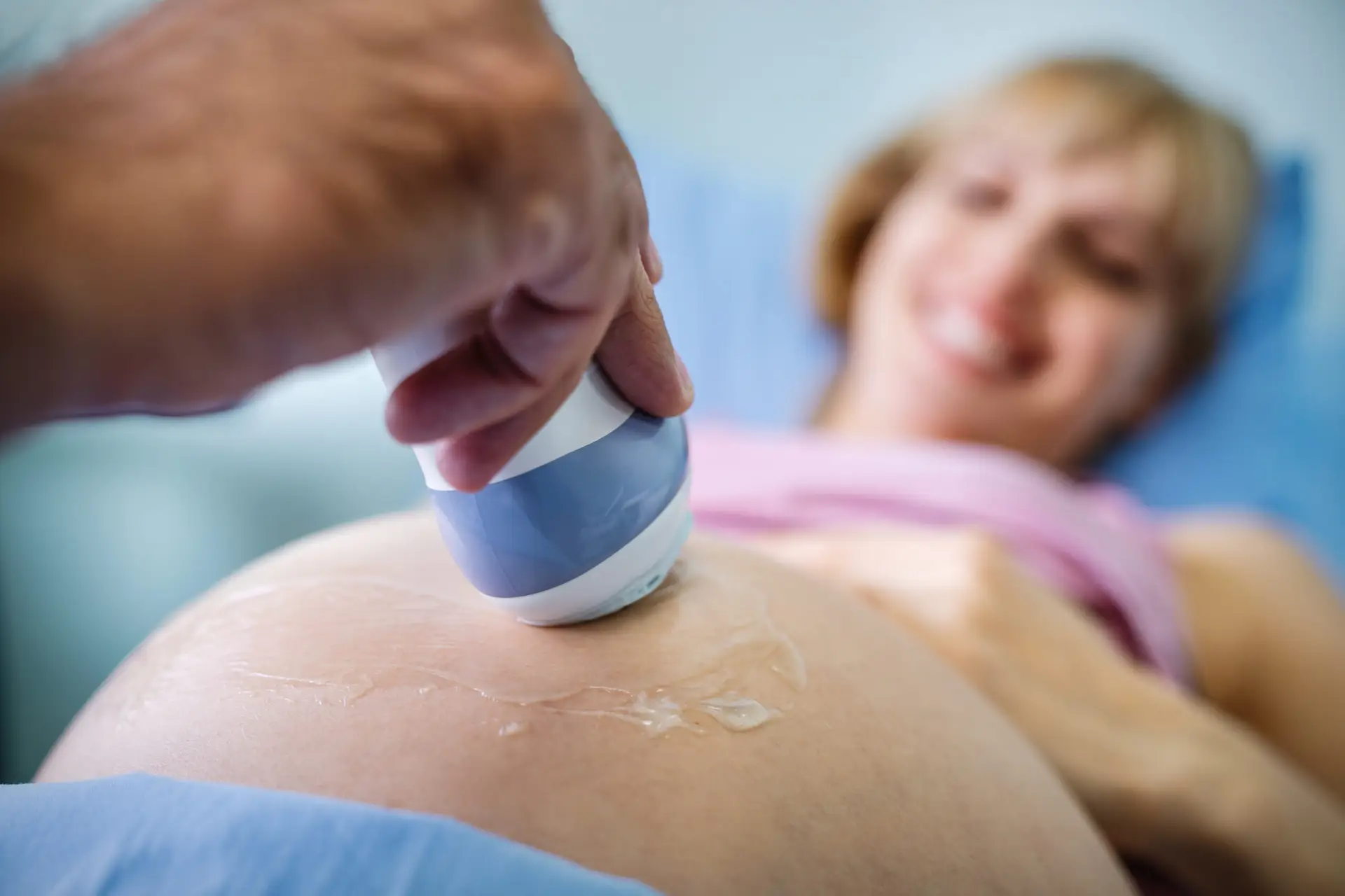 Examining pregnant woman belly by ultrasonic scan in clinic